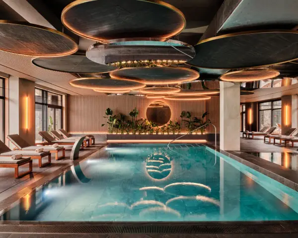 Nowoczesny basen w hotelu SPA z leżakami i roślinnością.