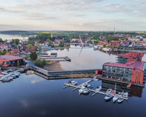 Widok z lotu ptaka na miasteczko nad jeziorem z mariną i nowoczesnymi budynkami.