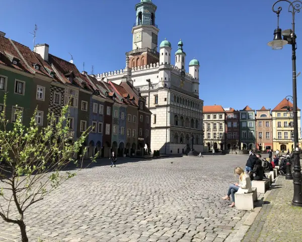 Rynek w Poznaniu z kolorowymi kamienicami i Ratuszem w tle.