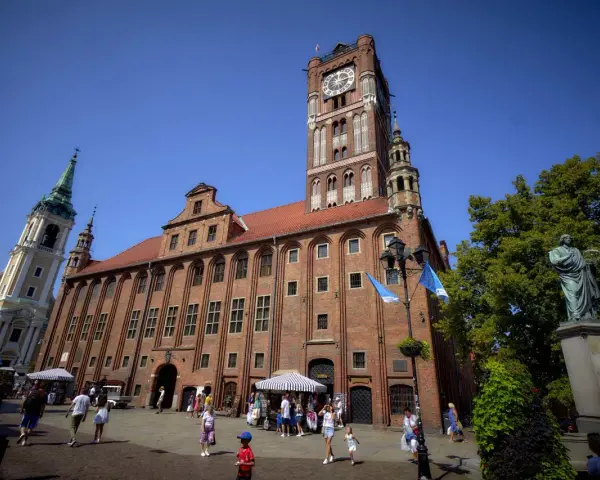 Ratusz Staromiejski w Toruniu z wieżą zegarową i pomnikiem Kopernika na Rynku Staromiejskim.