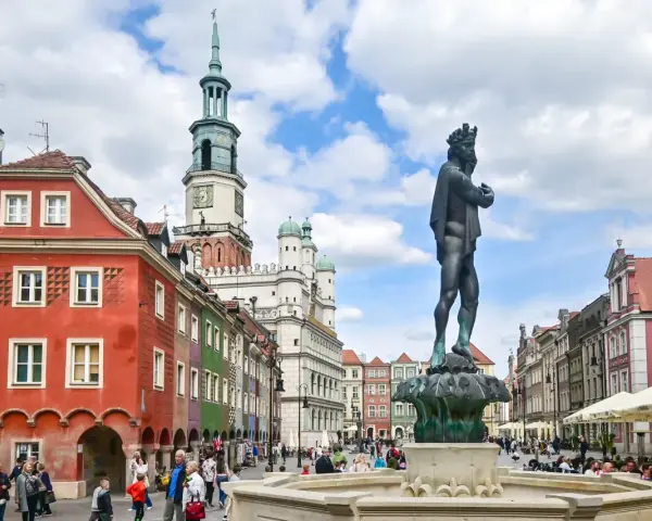 Rynek w Poznaniu z fontanną i kolorowymi kamienicami.