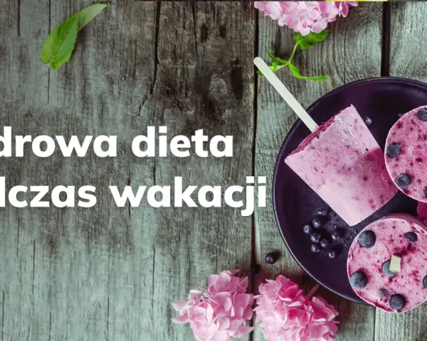 Lody jagodowe na patyku i w kształcie krążków na talerzu, ozdobione kwiatami.