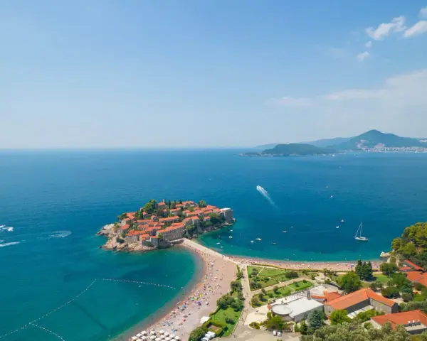 Wyspa Sveti Stefan w Czarnogórze z plażą i turkusowym morzem.
