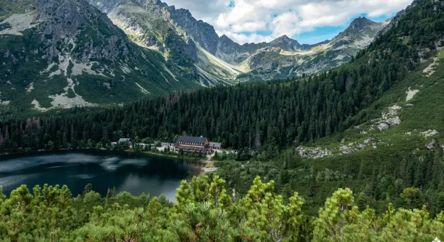 Popradzki Staw z hotelem i górami w tle.