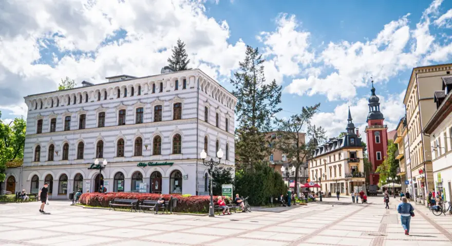 Rynek w Cieplicach Śląskich-Zdroju z zabytkowymi kamienicami i wieżą kościelną.