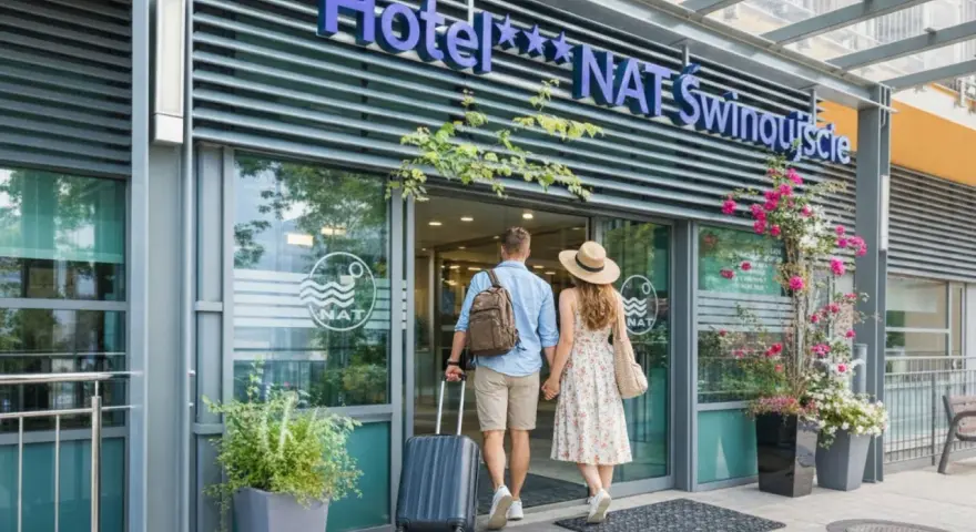 Para wchodzi do hotelu NAT Świnoujście z walizką i torbą.
