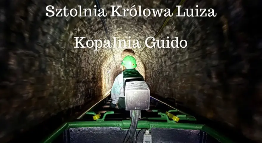 Osoba w kasku jedzie kolejką podziemną w sztolni.
