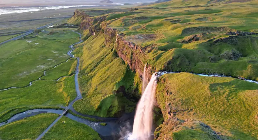 Wodospad Seljalandsfoss na Islandii w złotym świetle zachodzącego słońca.