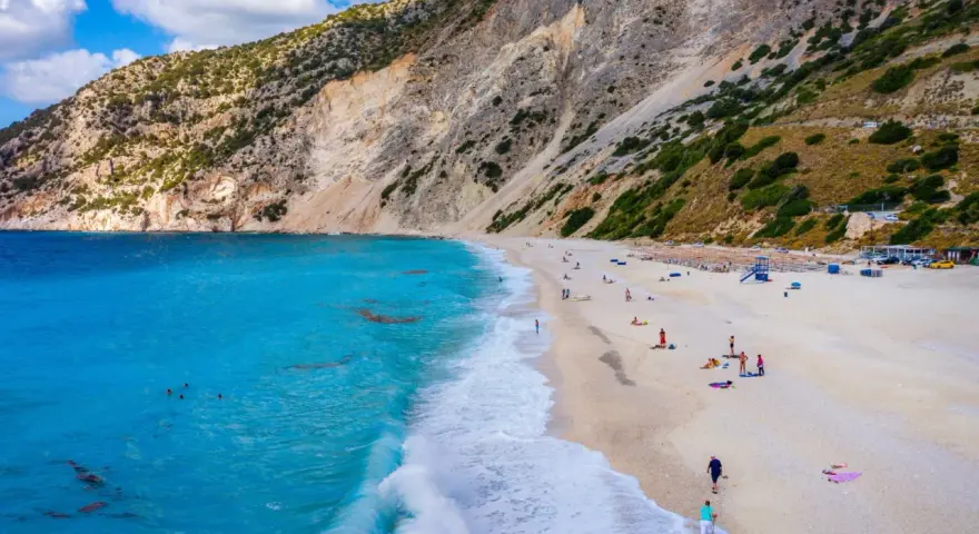 Widok z lotu ptaka na plażę Myrtos na Kefalonii z turkusową wodą i stromym klifem.