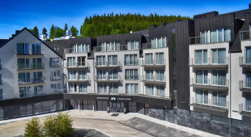 Nowoczesny apartamentowiec z balkonami, otoczony lasem. Idealne miejsce na czarna góra noclegi.