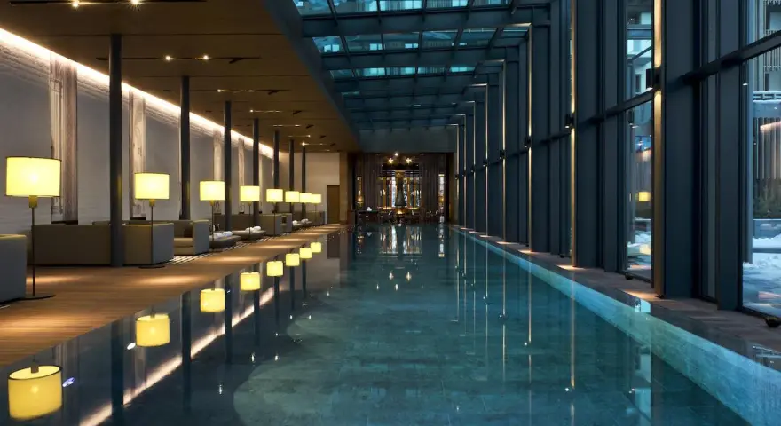 Nowoczesny basen w hotelu SPA z przeszklonym dachem i oświetleniem.