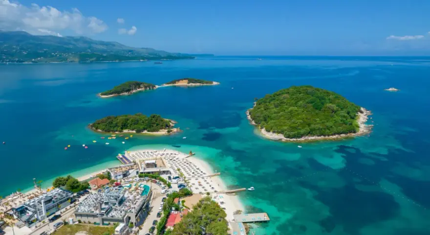 Widok z lotu ptaka na wyspy i plażę w Ksamilu, Albania, z turkusową wodą.