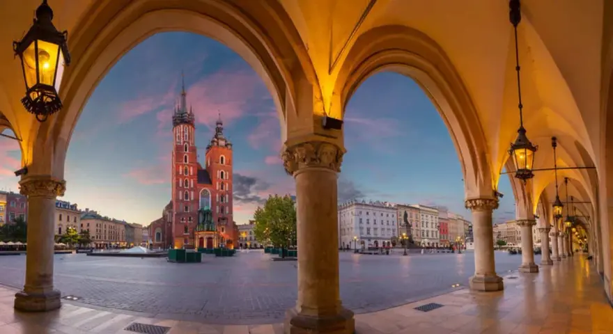 Sukiennice i Kościół Mariacki na Rynku Głównym w Krakowie o zachodzie słońca.