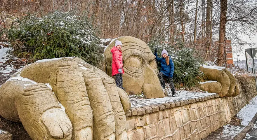Dwie dziewczynki przy kamiennych dłoniach i twarzy olbrzyma w Kudowie-Zdroju.