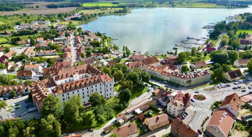 Widok z lotu ptaka na miasteczko nad jeziorem z zamkiem i mariną.