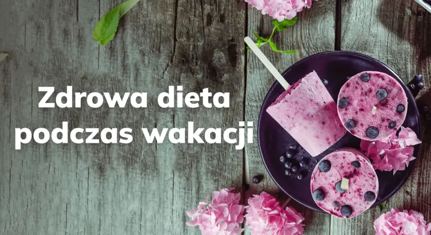 Lody jagodowe na patyku i w kształcie krążków na talerzu, ozdobione kwiatami.
